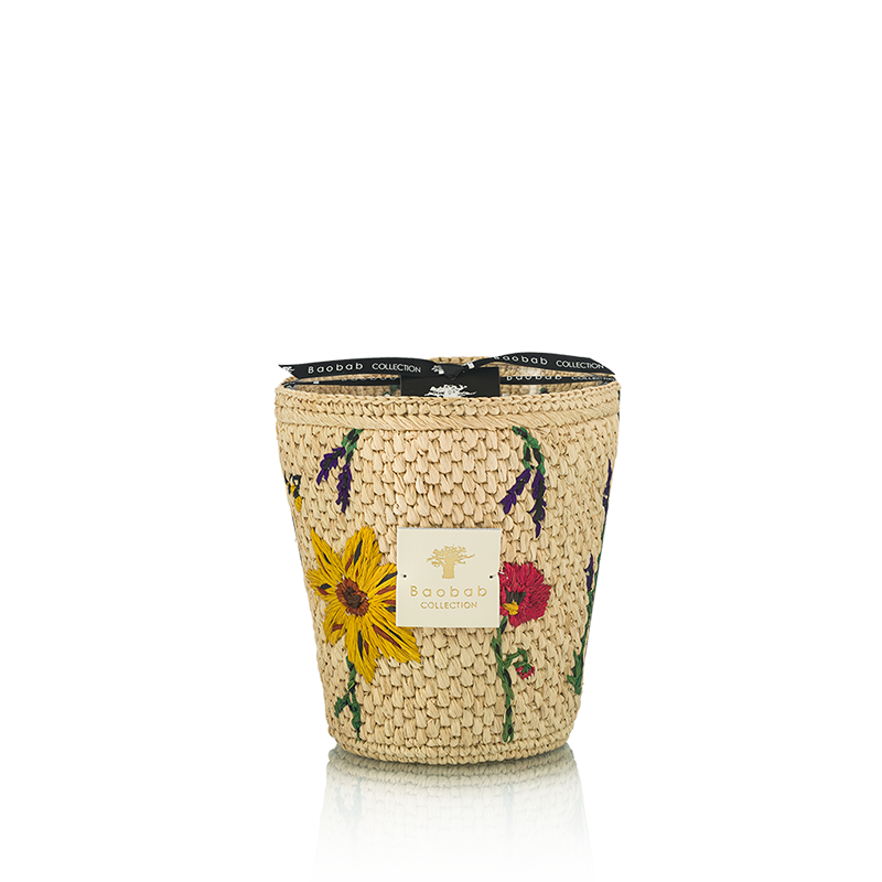 Vela en frasco de fibra tejida beige con flores amarillas y rojas, vista frontal