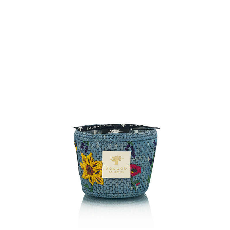 Vela en recipiente tejía azul con flores, etiqueta frontal y borde con cinta negra