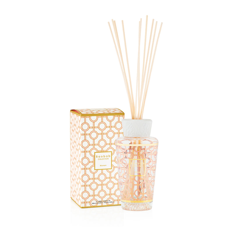 Difusor de aroma con varillas beige, frasco de vidrio con patrón naranja y caja a juego
