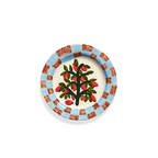 Plato llano decorado con árbol y frutos rojos sobre fondo claro.