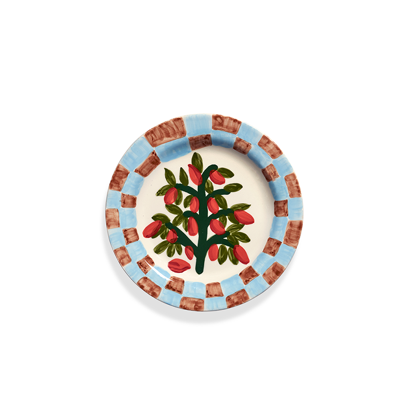 Plato llano decorado con árbol y frutos rojos sobre fondo claro.