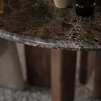 Mesa de comedor con sobre de mármol oscuro y patas de madera visibles