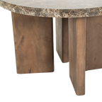 Mesa redonda de mármol marrón veteada con patas de madera al frente y vista del hueco