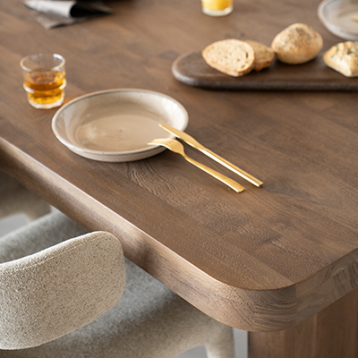 Mesa de comedor de madera natural con plato y cubiertos sobre el tablero