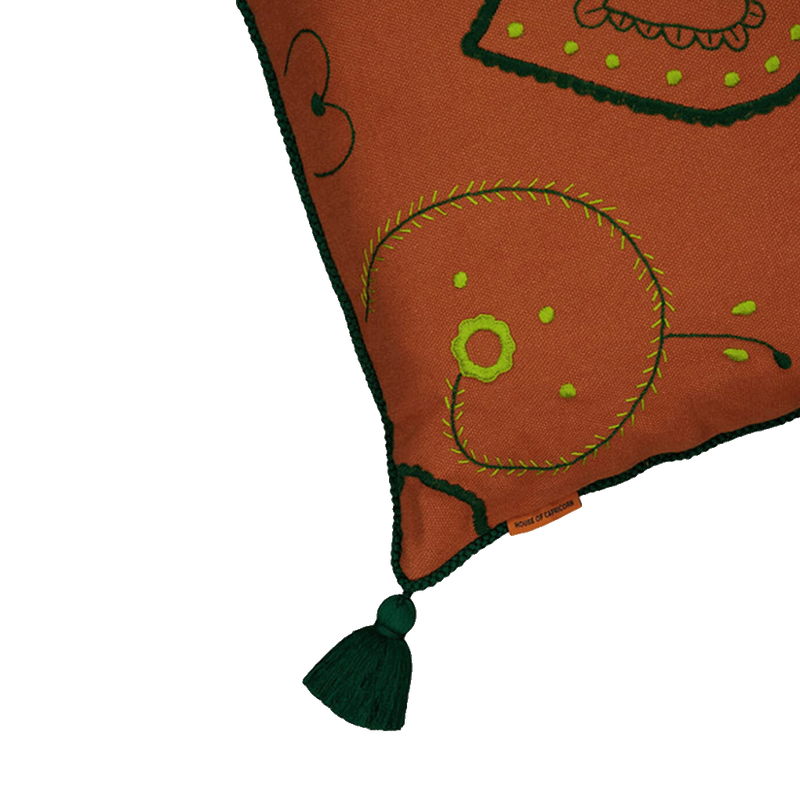 Cojín 60x60 con detalle de bordado verde sobre funda naranja ladrillo