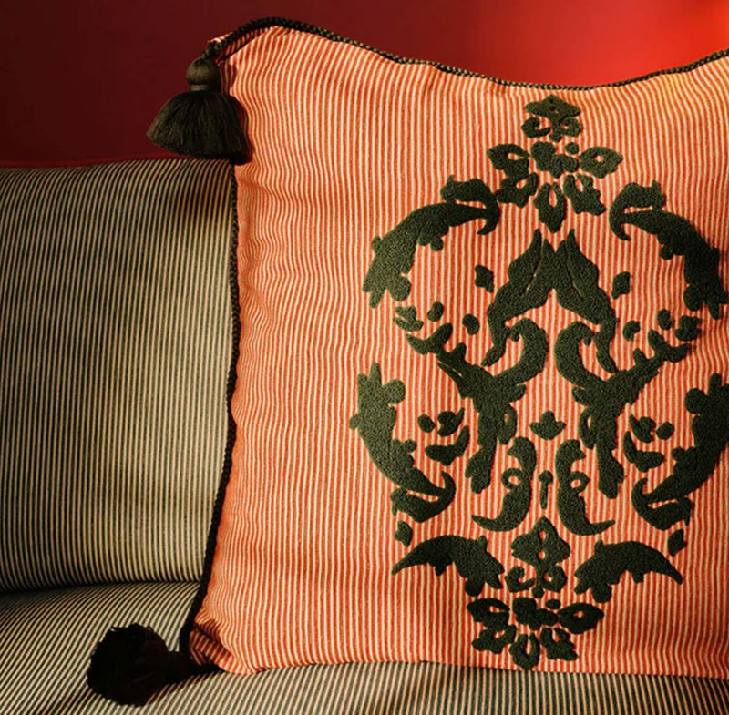 Cojín con rayas naranjas y bordado verde oscuro con motivos florales