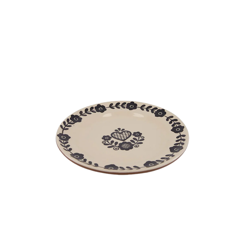 Plato llano crema con decoración negra de corazón y ramas en el centro