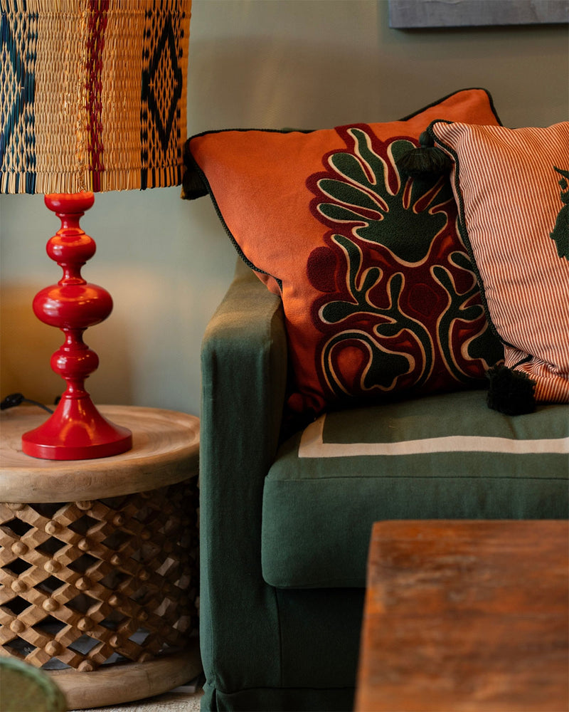 Sofá de lino verde de tres plazas con cojines decorativos y asiento con costuras