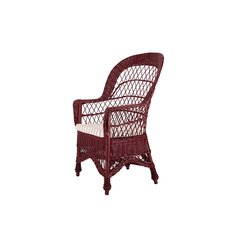 Sillón de mimbre burdeos con respaldo tejido y cojín a rayas