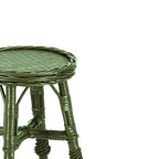 Taburete de mimbre verde, detalle del asiento tejido y uniones de las patas