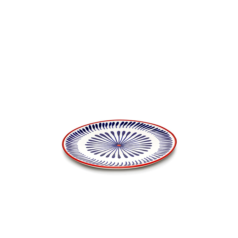 Plato llano azul con patrón espiral floral y borde rojo, sobre fondo blanco.