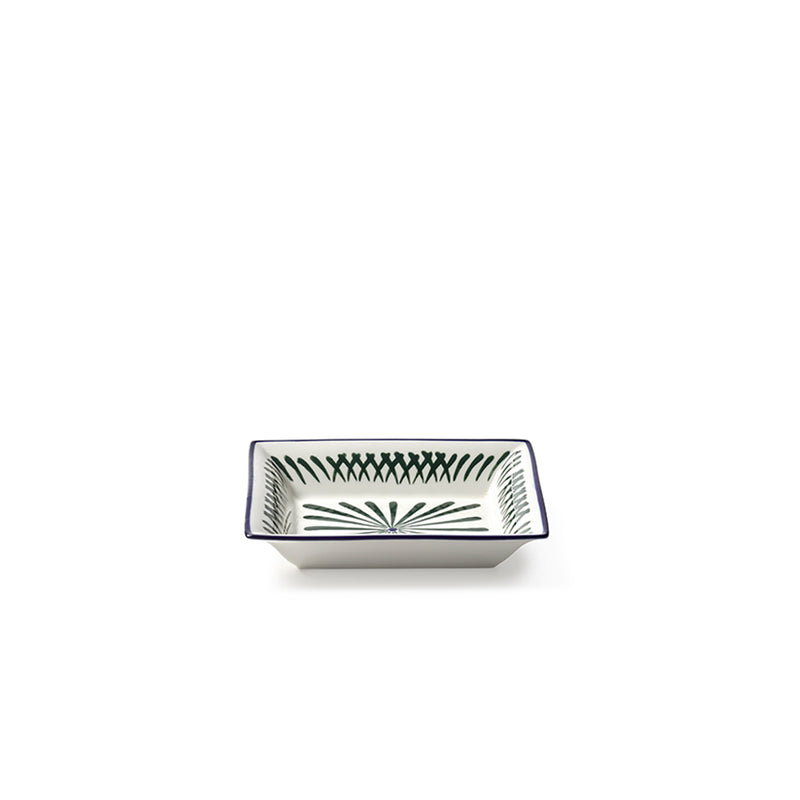 Plato rectangular con borde azul y patrón verde-azul sobre cerámica blanca.