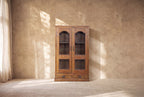 Vitrina de madera estilo artesanal con dos puertas y paneles con forma arqueada