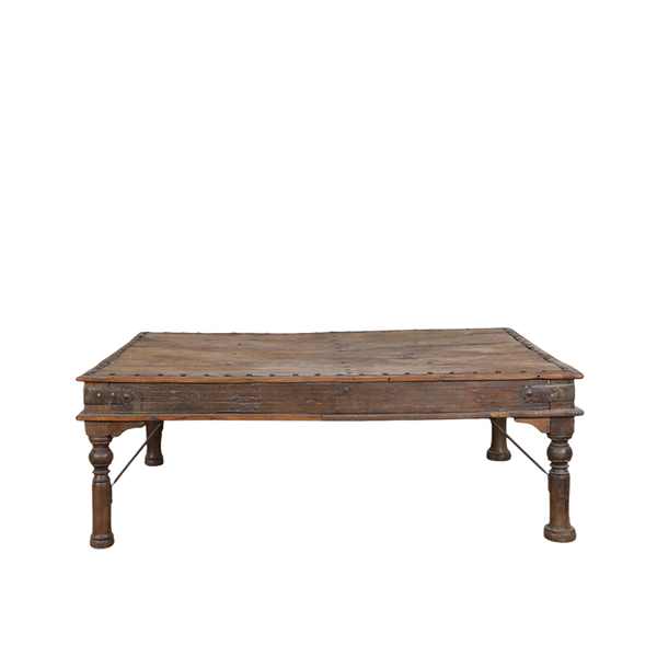 Mesa de comedor artesanal de madera oscura con patas torneadas y bordes marcados
