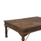 Mesa de comedor de madera oscura con tablero liso y esquinas reforzadas