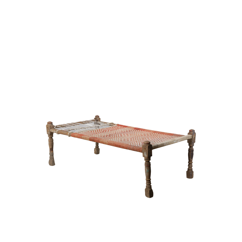 Cama charpai tradicional tejida roja y blanca con base rectangular y patas de madera