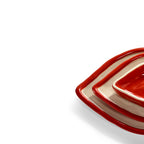 Detalle de bandeja decorativa con forma de labios, borde rojo y base beige