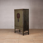 Armario antiguo verde con puertas cerradas y manijas metálicas, vista lateral