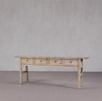 Consola antigua de madera clara con 4 cajones, vista lateral izquierda, aspecto envejecido