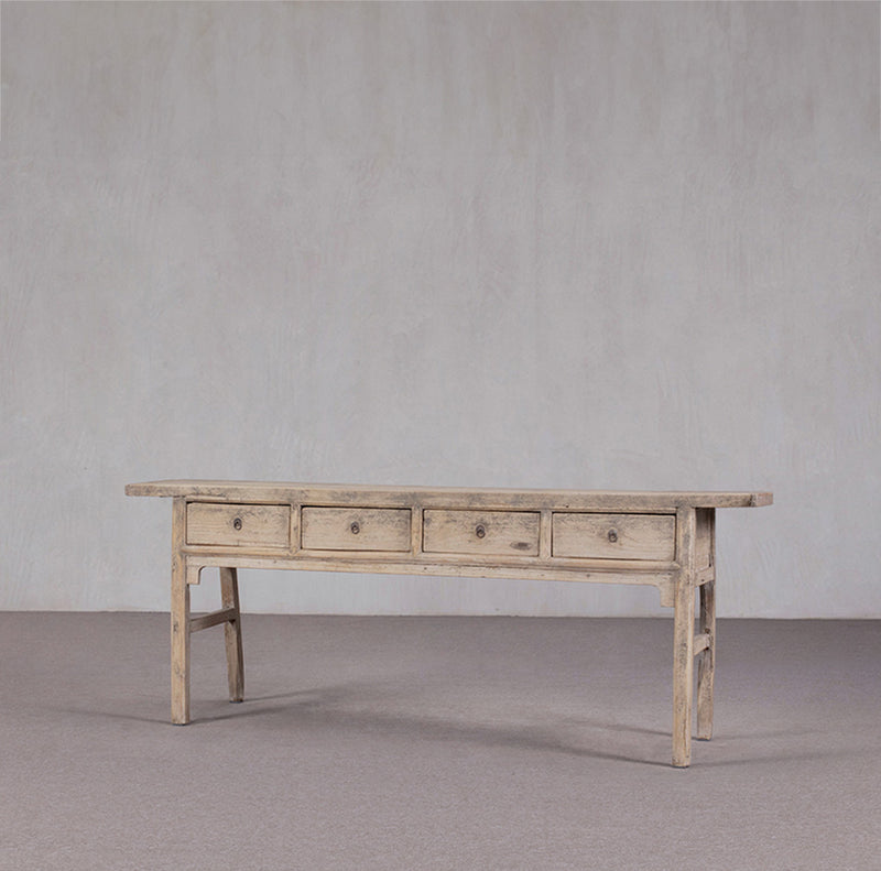 Consola antigua de madera clara con 4 cajones, vista lateral izquierda, aspecto envejecido