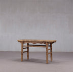 Consola antigua de madera con tablero rectangular y patas de madera, vista lateral con travesaños