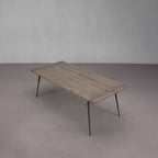 Mesa de comedor de madera con acabado envejecido, tablero rectangular y patas oblicuas.