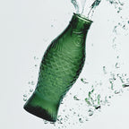 Jarra de cristal verde oscuro con salpicaduras de agua alrededor