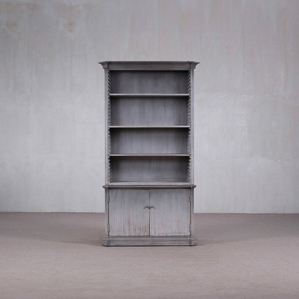 Librería alta de madera con estantes y puertas inferiores, acabado gris envejecido