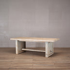 Mesa de comedor rectangular con travesaño inferior y acabado rústico en madera de olmo.