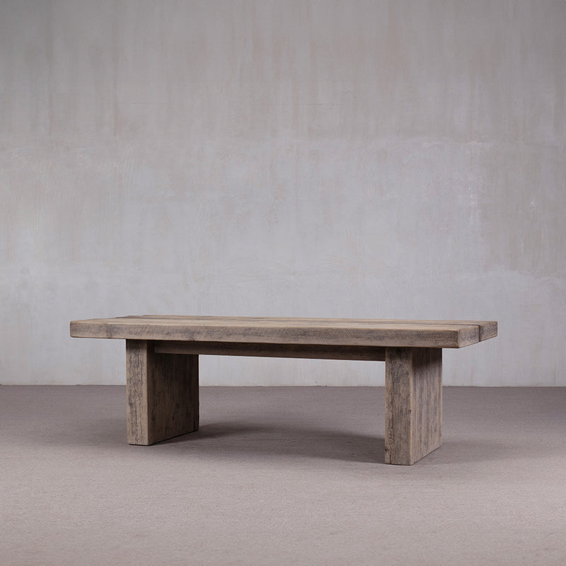Mesa de comedor larga de madera maciza gris, vista en ángulo con patas rectas