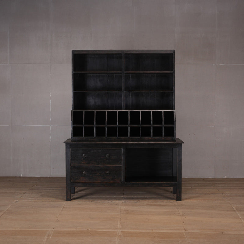 Librería negra de madera con casilleros y cajones inferiores