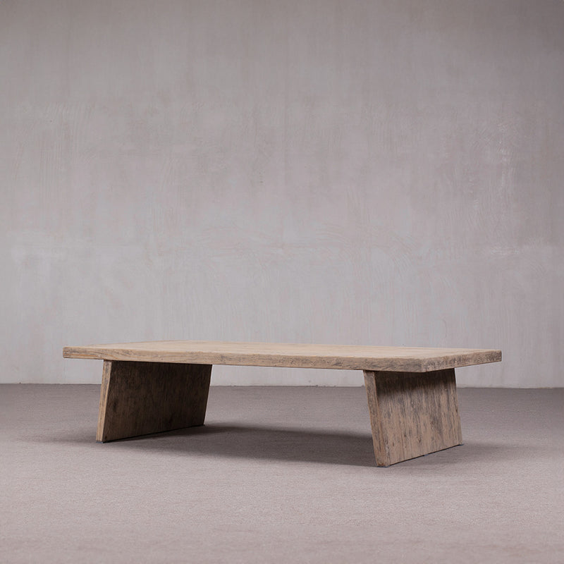 Mesa de centro rectangular de madera vista lateral, tablero liso y patas de bloque