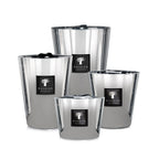 Juego de cuatro velas en recipientes plateados con tapas abiertas y etiquetas Baobab