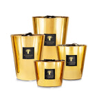 Juego de 4 velas en vasos de vidrio dorado con etiqueta Baobab Collection.
