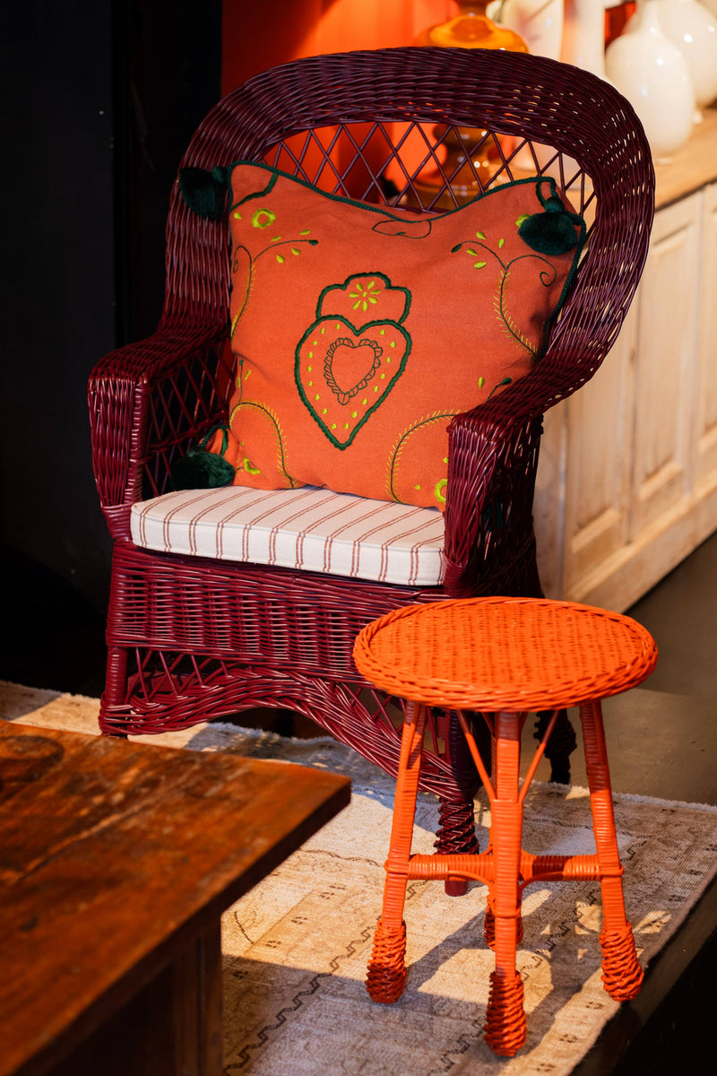 Cojín 60x60 con estampado de corazones verde sobre fondo naranja ladrillo y borlas