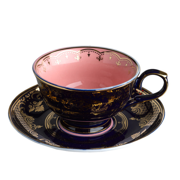 Taza de té con interior rosa y esmalte azul oscuro con motivos dorados y asa