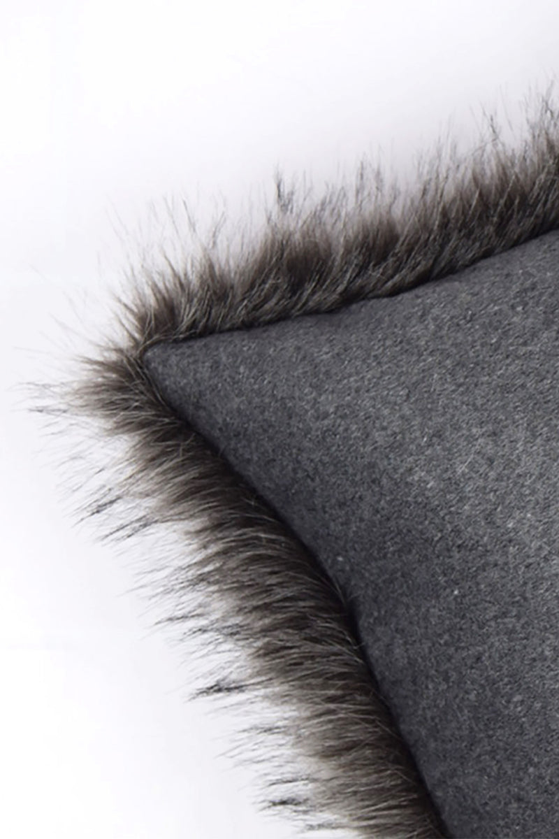 Cojín con ribete de pelo sintético y funda de tela gris, vista lateral