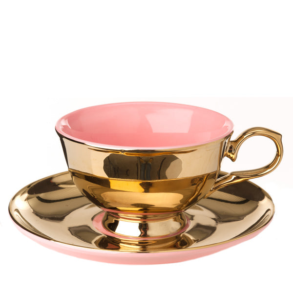 Taza de té con plato, interior rosado y exterior dorado con asa
