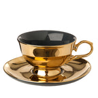 Taza de té con plato, interior negro y exterior dorado, con asa