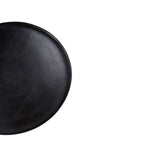 Tapa circular negra con acabado liso y ligero relieve