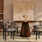 Mesa de comedor redonda de madera oscura con tapa y pedestal central cónico