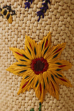 Detalle de frasco de vela tejido con flor amarilla y toques morados