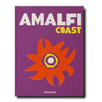 Libro de tapa morada con “AMALFI COAST” y flor naranja sobre fondo liso.