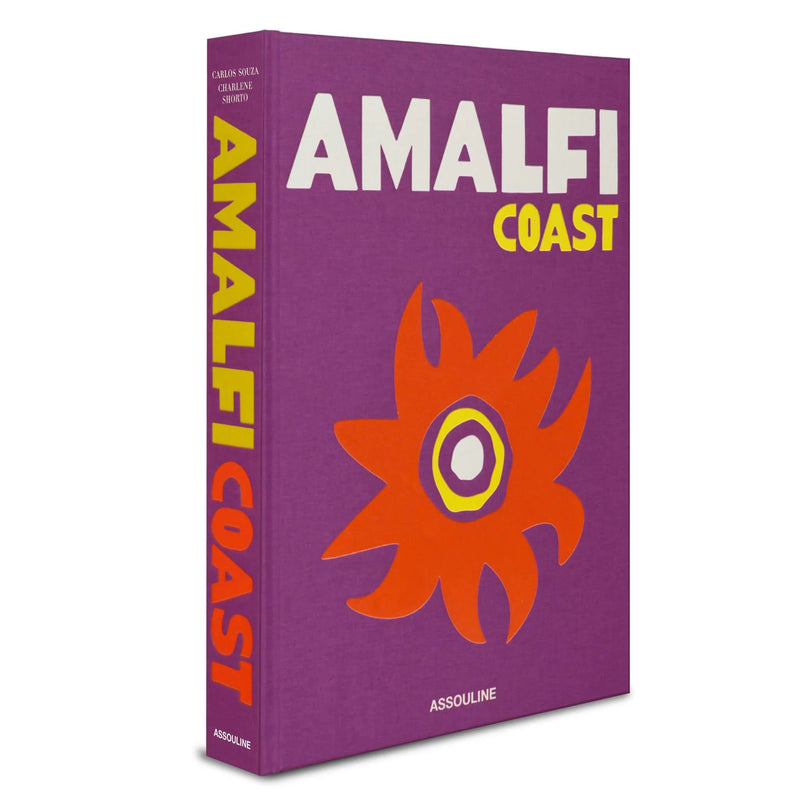 Libro con lomo “AMALFI COAST”, portada morada y flor naranja con logo ASSOULINE.