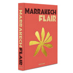 Libro Marrakech Flair coral con tipografía grande y flor amarilla en portada