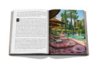 Libro abierto con fotos de jardín y patio con palmeras y fuente
