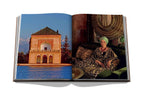 Libro abierto con foto de edificio junto a agua y retrato con vestido estampado