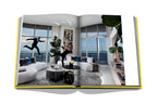 Libro de fotografía abierto con interiores modernos, sala con sofás y plantas