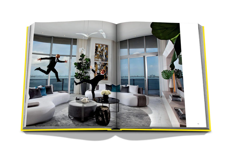 Libro de fotografía abierto con interiores modernos, sala con sofás y plantas