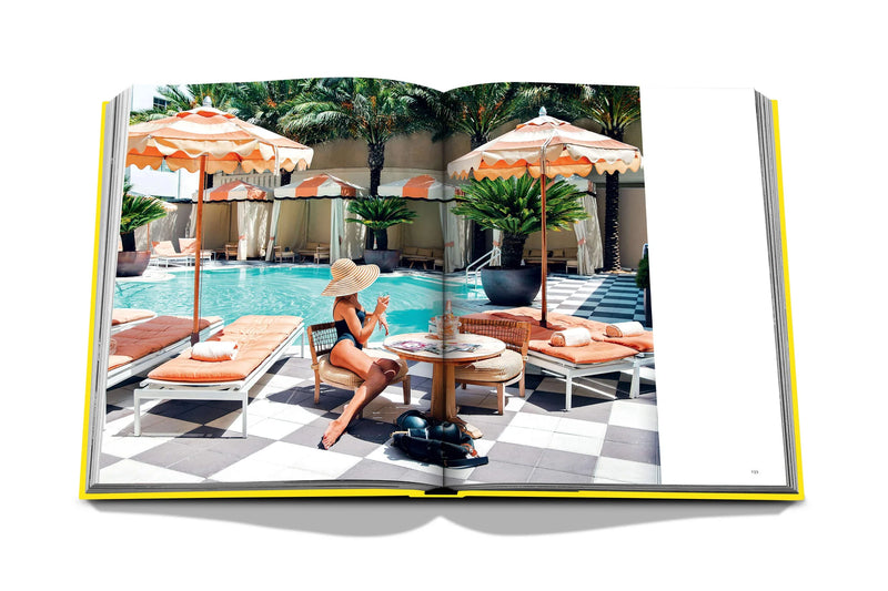 Libro de fotografía abierto con piscina, tumbonas y persona con bikini